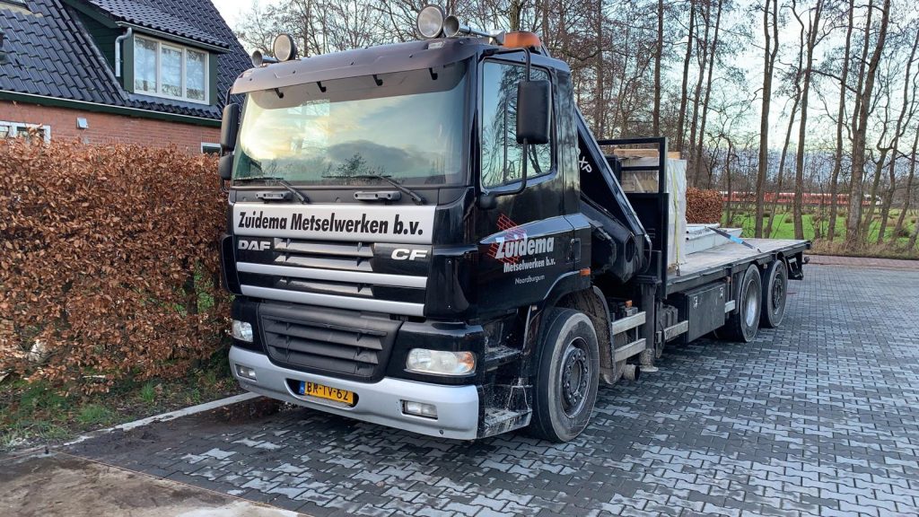 Vrachtwagen met laadkraan en de belettering Zuidema Metselwerken b.v.