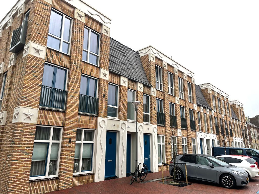 De gevelrij langs de straat, gezien vanaf straatniveau