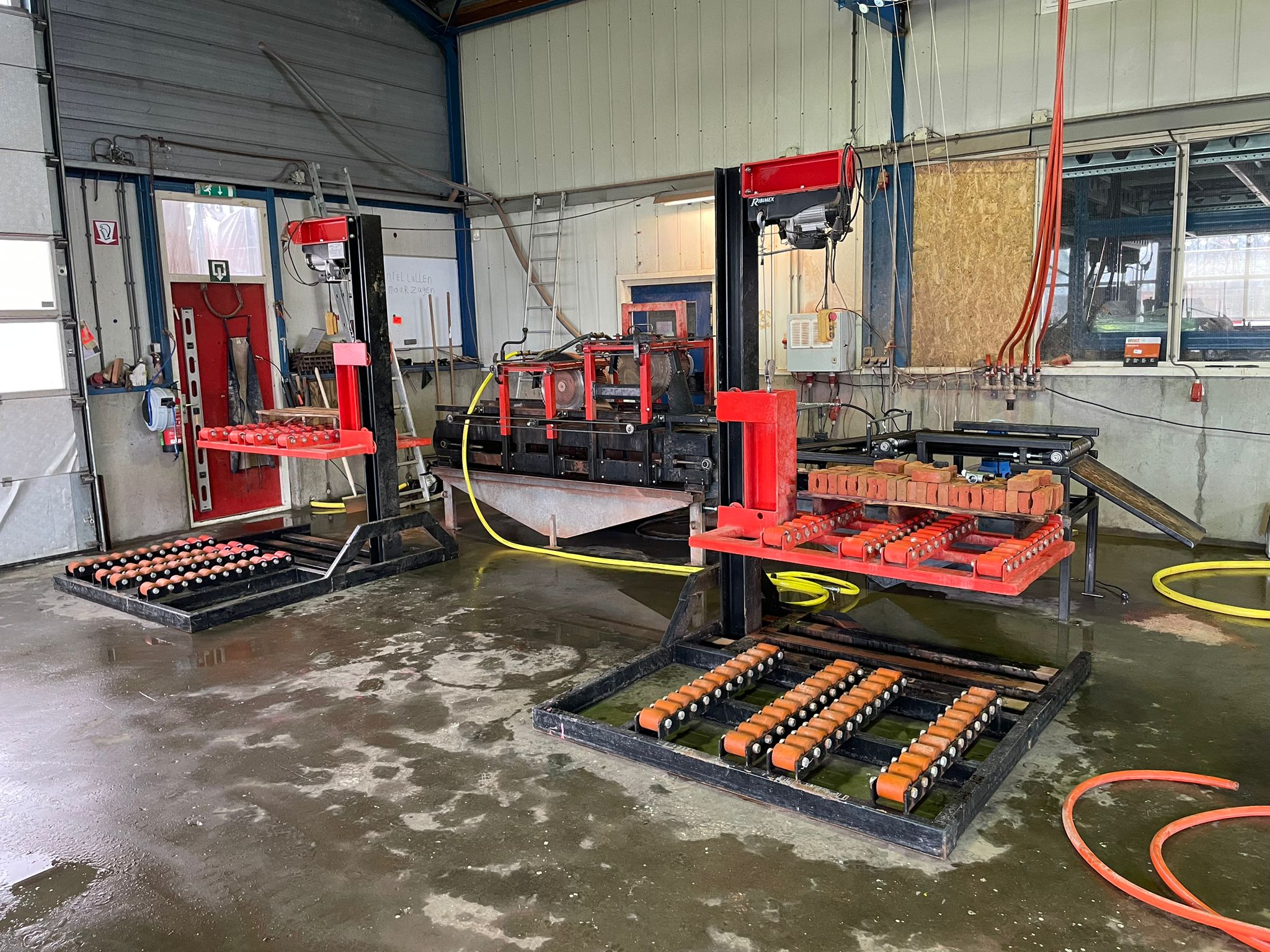 Twee rode zaagbanken met rollenbanen in de zaaghal